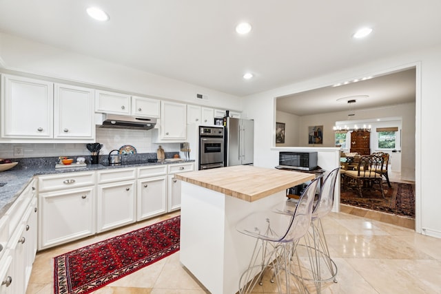 6227 Bandera Ave Unit D, Dallas, TX 75225 - kitchen with under cabinet range hood, white cabinetry, tasteful backsplash, and recessed lighting