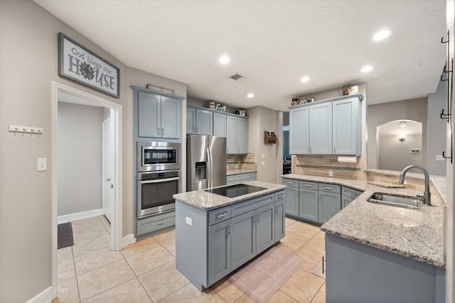 2213 Laura Elizabeth Trl, Mansfield, TX 76063 - kitchen with stainless steel appliances, tasteful backsplash, a kitchen island, arched walkways, and light stone counters