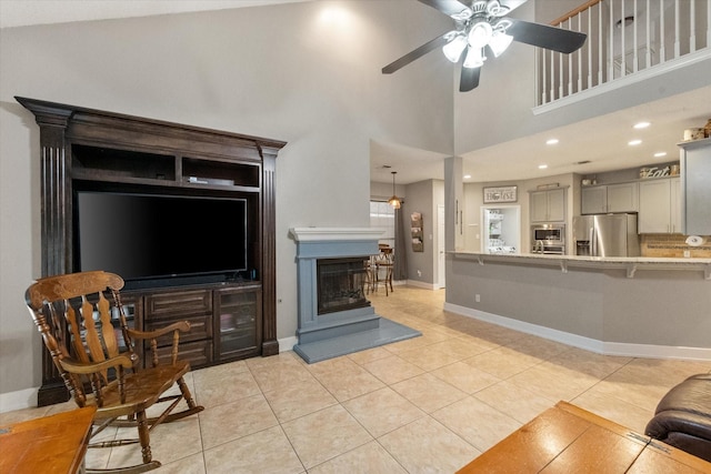2213 Laura Elizabeth Trl, Mansfield, TX 76063 - living area featuring light tile patterned flooring, a ceiling fan, a fireplace with raised hearth, and a towering ceiling
