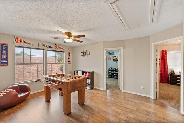 2213 Laura Elizabeth Trl, Mansfield, TX 76063 - game room with attic access, ceiling fan, light wood-style flooring, and a textured ceiling