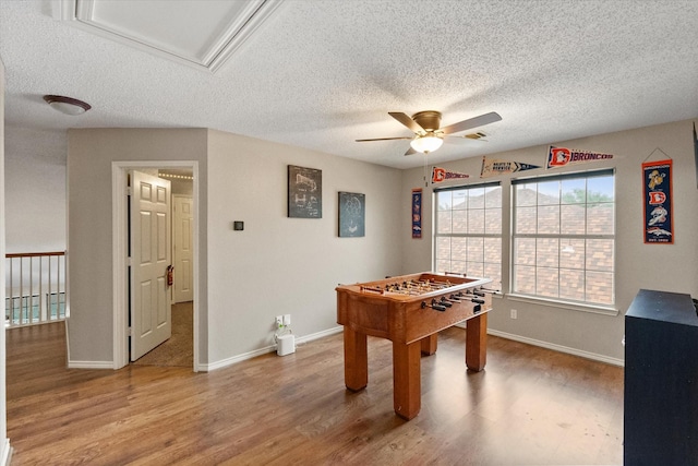 2213 Laura Elizabeth Trl, Mansfield, TX 76063 - recreation room featuring a ceiling fan, light wood finished floors, a textured ceiling, and attic access