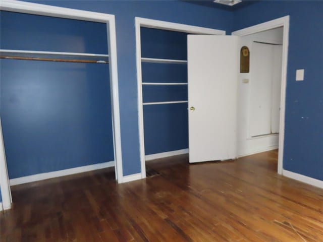 9066 Orinoco Dr, Dallas, TX 75217 - unfurnished bedroom with wood finished floors and two closets