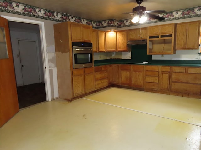 9066 Orinoco Dr, Dallas, TX 75217 - kitchen featuring oven, under cabinet range hood, ceiling fan, brown cabinetry, and stovetop