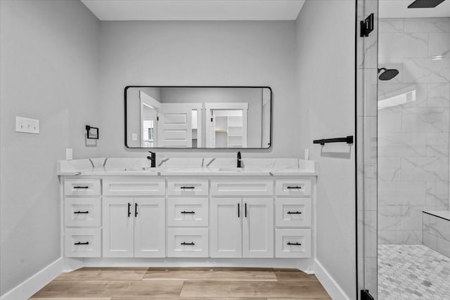 13017 Rainier, Woodway, TX 76712 - bathroom with a marble finish shower, double vanity, and wood finished floors