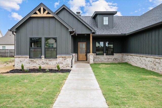 13017 Rainier, Woodway, TX 76712 - view of front of house with board and batten siding, a front lawn, roof with shingles, brick siding, and a chimney