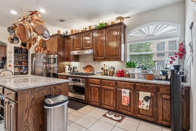 4105 Claridge Ter, Garland, TX 75043 - kitchen featuring stainless steel appliances, a kitchen island, light tile patterned floors, light stone countertops, and recessed lighting