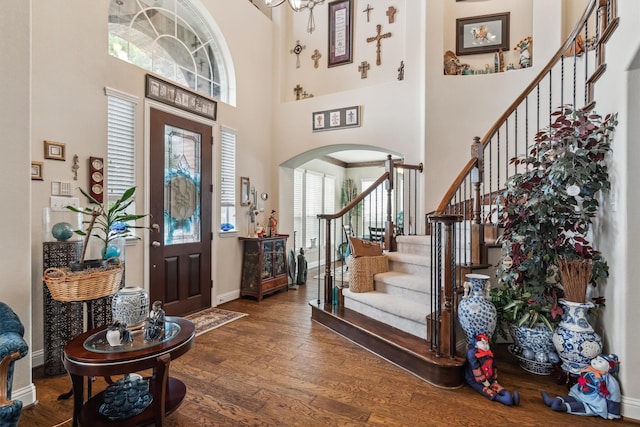 4105 Claridge Ter, Garland, TX 75043 - entrance foyer featuring arched walkways, wood finished floors, a towering ceiling, and stairway