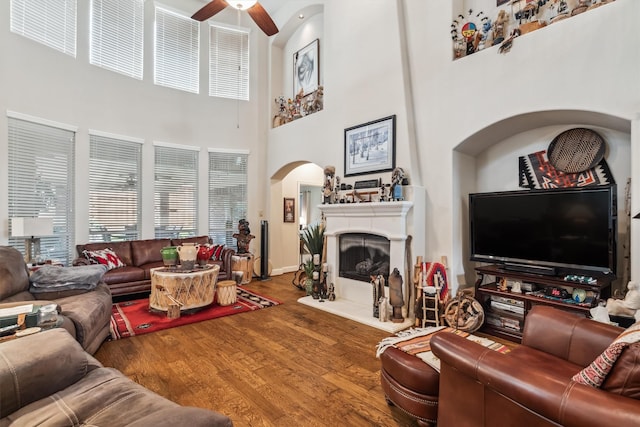 4105 Claridge Ter, Garland, TX 75043 - living room with ceiling fan, wood finished floors, arched walkways, a towering ceiling, and a fireplace with raised hearth