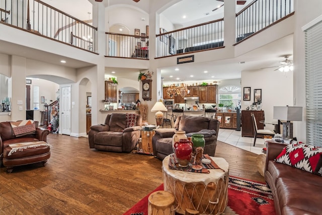 4105 Claridge Ter, Garland, TX 75043 - living area featuring ceiling fan, arched walkways, light wood-style floors, a towering ceiling, and ornate columns