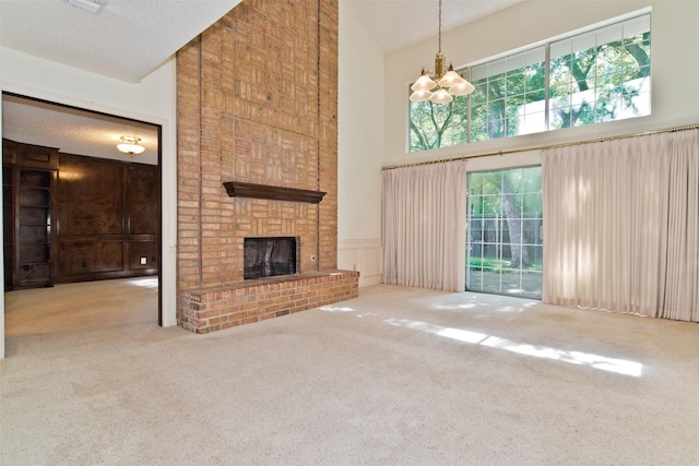 748 Arbor Creek Dr, Desoto, TX 75115 - unfurnished living room with a towering ceiling, a chandelier, carpet, a brick fireplace, and a wainscoted wall