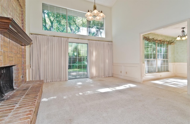 748 Arbor Creek Dr, Desoto, TX 75115 - unfurnished living room with a chandelier, a high ceiling, plenty of natural light, wainscoting, and carpet flooring