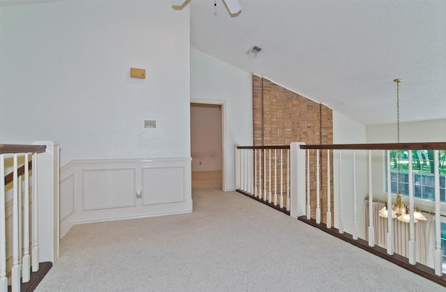 748 Arbor Creek Dr, Desoto, TX 75115 - hallway with lofted ceiling, carpet, a chandelier, a wainscoted wall, and a decorative wall