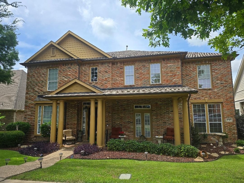 1717 E Branch Hollow Dr, Carrollton, TX 75007 - view of front facade featuring a front yard and brick siding