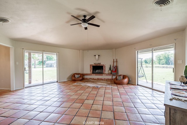 2306 County Road 475, Anson, TX 79501 - living area featuring ceiling fan, a fireplace with raised hearth, and light tile patterned flooring