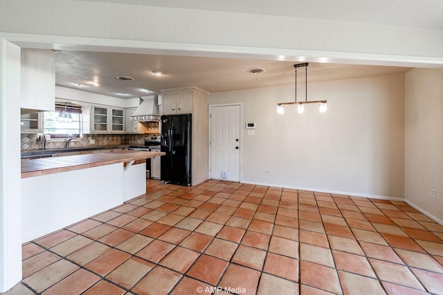 2306 County Road 475, Anson, TX 79501 - kitchen featuring black refrigerator with ice dispenser, wall chimney exhaust hood, electric stove, tasteful backsplash, and glass insert cabinets