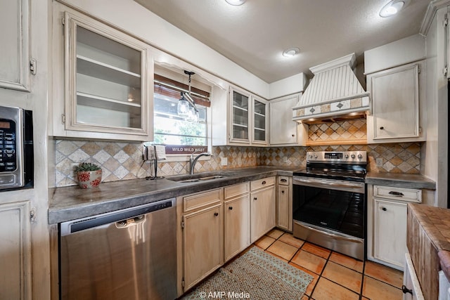 2306 County Road 475, Anson, TX 79501 - kitchen with stainless steel appliances, premium range hood, dark countertops, decorative backsplash, and glass insert cabinets