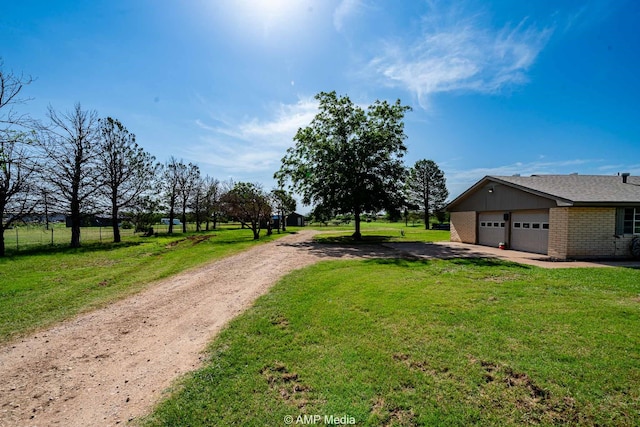 2306 County Road 475, Anson, TX 79501 - view of green lawn with dirt driveway and an attached garage