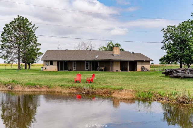 2306 County Road 475, Anson, TX 79501 - view of front of home featuring brick siding, a chimney, a water view, and a front lawn