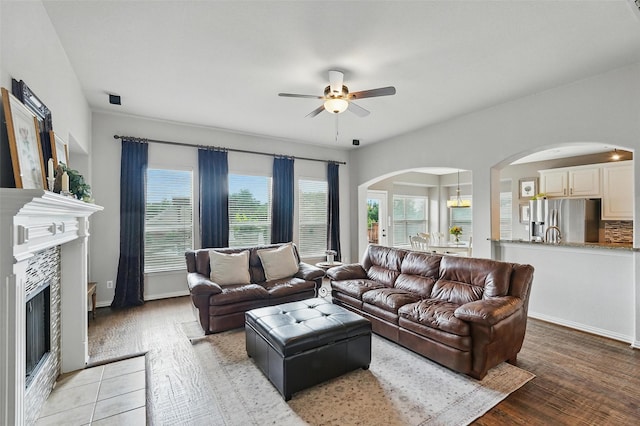 1330 Scarboro Hills Ln, Rockwall, TX 75087 - living room featuring a ceiling fan, arched walkways, light wood-style floors, and a fireplace