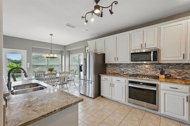 1330 Scarboro Hills Ln, Rockwall, TX 75087 - kitchen featuring stainless steel appliances, decorative backsplash, a chandelier, and white cabinets