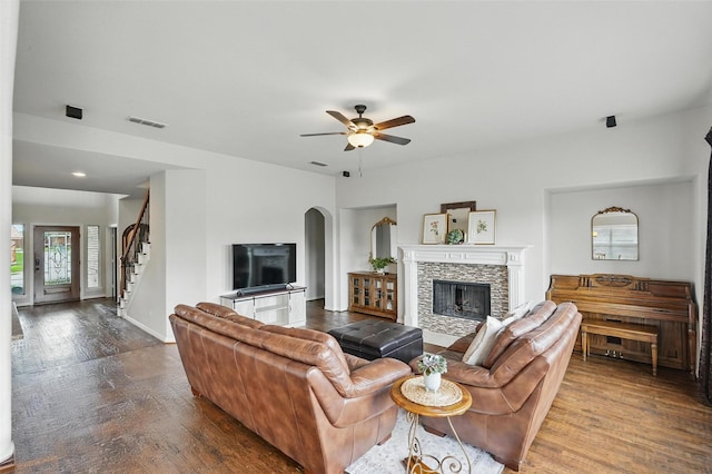 1330 Scarboro Hills Ln, Rockwall, TX 75087 - living room featuring wood finished floors, a stone fireplace, stairs, ceiling fan, and arched walkways