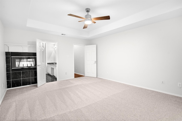908 Trinity Dr, Lancaster, TX 75146 - unfurnished bedroom with carpet, a raised ceiling, a fireplace, and ceiling fan