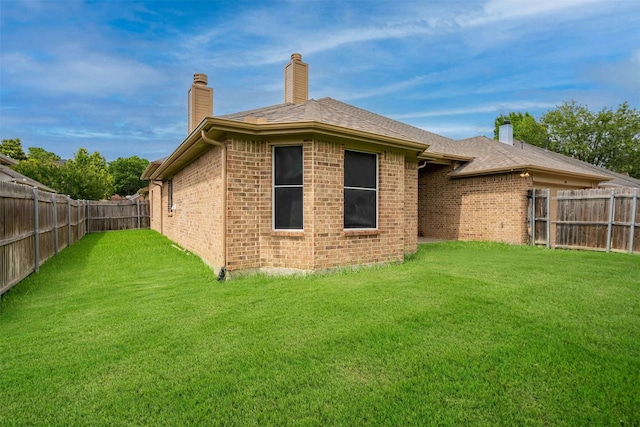 908 Trinity Dr, Lancaster, TX 75146 - back of house with a chimney, a fenced backyard, brick siding, and a shingled roof