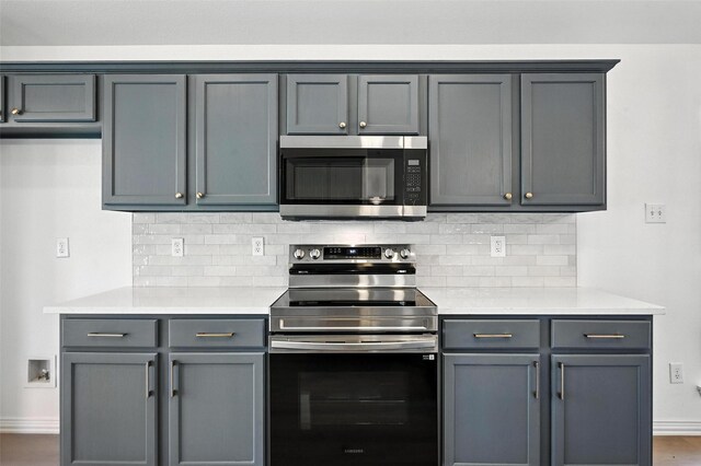 713 Madeline Ct, Azle, TX 76020 - kitchen featuring appliances with stainless steel finishes, tasteful backsplash, light countertops, and gray cabinetry