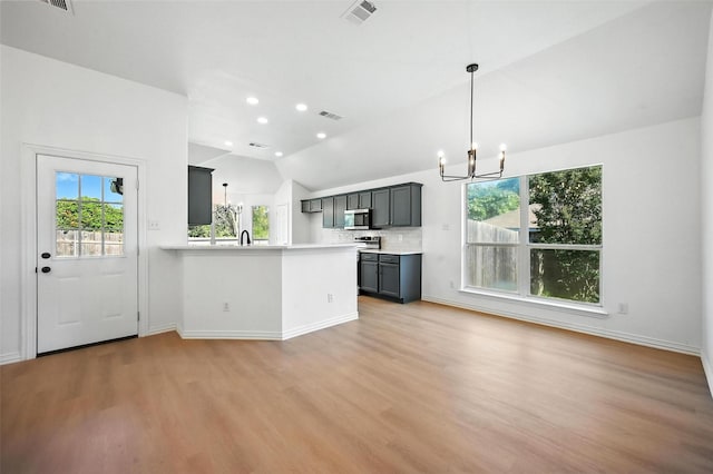 713 Madeline Ct, Azle, TX 76020 - kitchen with a chandelier, stainless steel microwave, lofted ceiling, healthy amount of natural light, and light countertops