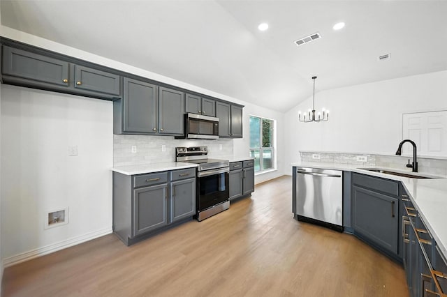 713 Madeline Ct, Azle, TX 76020 - kitchen with appliances with stainless steel finishes, vaulted ceiling, light wood-style floors, a chandelier, and tasteful backsplash