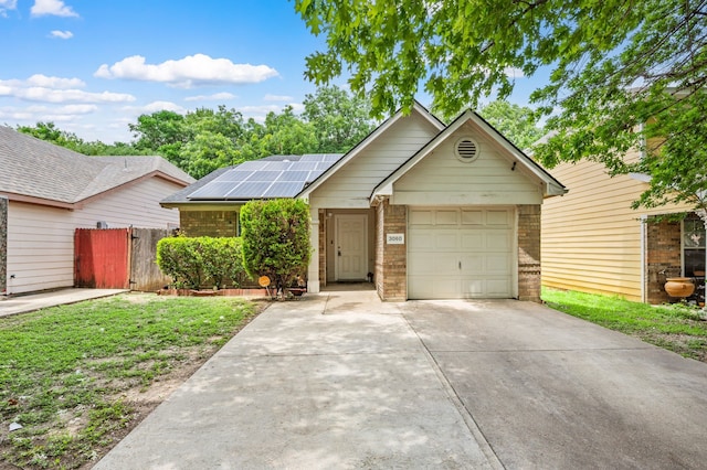 3060 Saint Nicholas Dr, Dallas, TX 75233 - ranch-style house with roof mounted solar panels, concrete driveway, a garage, and brick siding