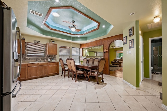 3060 Saint Nicholas Dr, Dallas, TX 75233 - dining space featuring a ceiling fan, a raised ceiling, and light tile patterned flooring