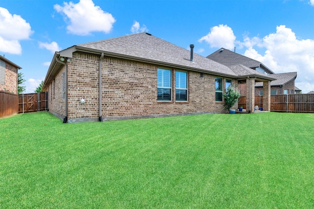 9809 Trinity Dr, Little Elm, TX 75068 - rear view of property featuring brick siding, a fenced backyard, and roof with shingles