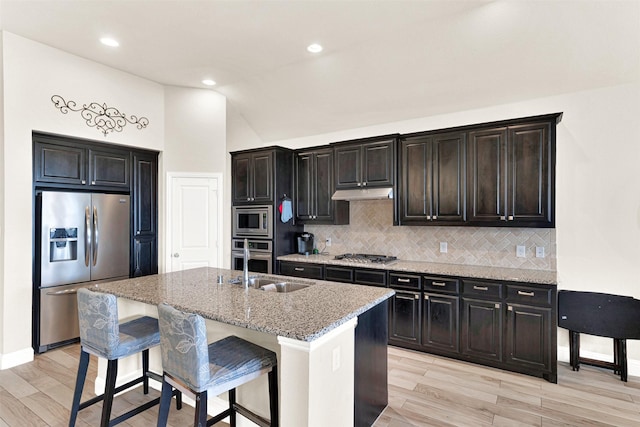 9809 Trinity Dr, Little Elm, TX 75068 - kitchen with stainless steel appliances, backsplash, light stone countertops, a kitchen breakfast bar, and a center island with sink