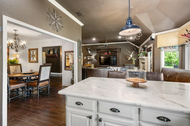 3901 Woodside Dr, Arlington, TX 76016 - kitchen with crown molding, a textured ceiling, dark wood-style flooring, vaulted ceiling, and white cabinets
