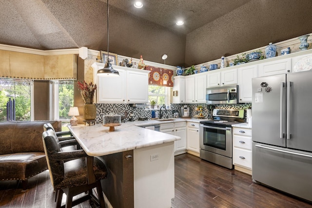 3901 Woodside Dr, Arlington, TX 76016 - kitchen featuring stainless steel appliances, a peninsula, white cabinets, light countertops, and decorative backsplash