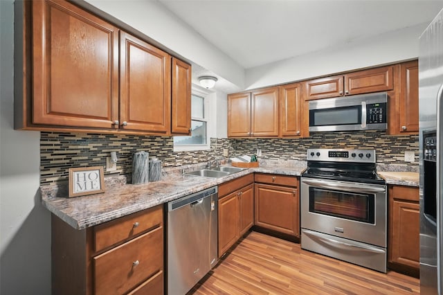 515 Signal Hill Ct S, Fort Worth, TX 76112 - kitchen with stainless steel appliances, light wood finished floors, decorative backsplash, and brown cabinetry