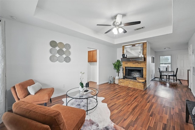 515 Signal Hill Ct S, Fort Worth, TX 76112 - living room featuring a raised ceiling, ceiling fan, a fireplace, and wood finished floors