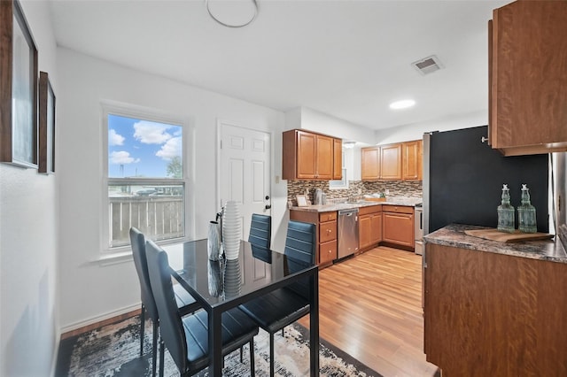 515 Signal Hill Ct S, Fort Worth, TX 76112 - kitchen featuring stainless steel appliances, light wood-style flooring, backsplash, and brown cabinets