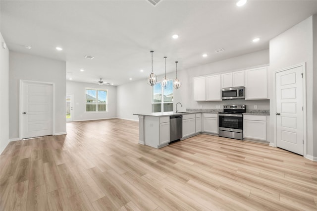 4020 Centerfire Rd, Waco, TX 76705 - kitchen featuring appliances with stainless steel finishes, open floor plan, white cabinetry, a peninsula, and recessed lighting