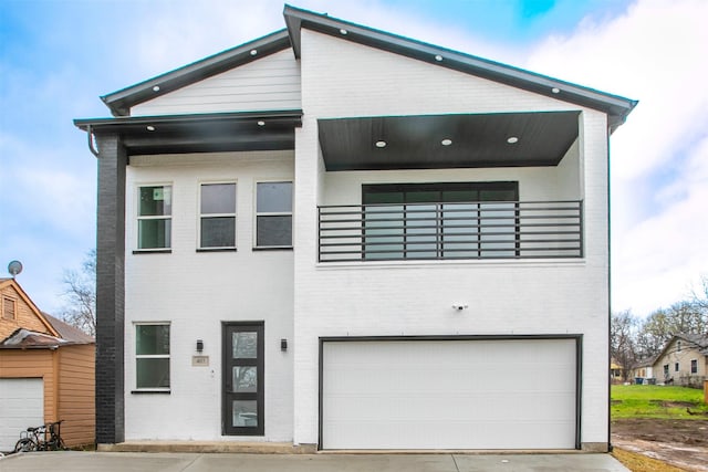 407 Dubois Ave, Dallas, TX 75203 - contemporary home featuring a balcony, brick siding, an attached garage, and driveway