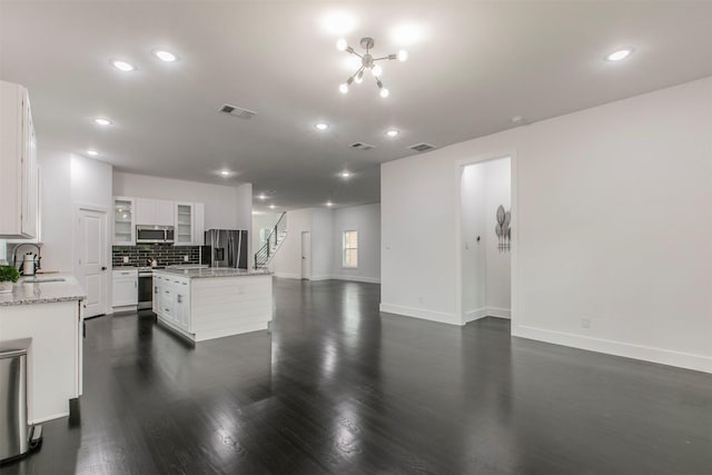 407 Dubois Ave, Dallas, TX 75203 - kitchen with stainless steel appliances, dark wood-style flooring, recessed lighting, tasteful backsplash, and a kitchen island
