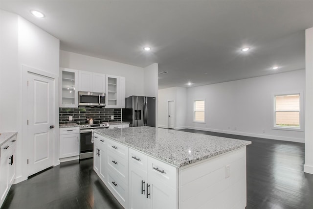 407 Dubois Ave, Dallas, TX 75203 - kitchen featuring stainless steel appliances, dark wood-style flooring, a kitchen island, tasteful backsplash, and glass insert cabinets