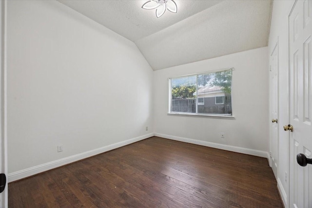 1701 Prairie Creek Ct, Garland, TX 75040 - unfurnished bedroom with lofted ceiling, dark wood finished floors, and a textured ceiling
