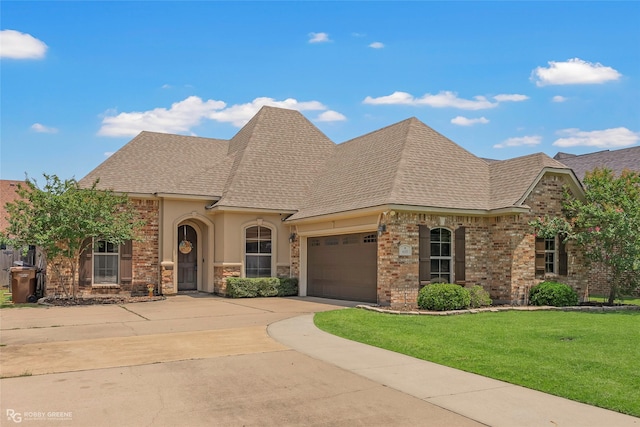 615 Canoe Trl, Bossier City, LA 71111 - french provincial home featuring driveway, an attached garage, a front lawn, roof with shingles, and stucco siding