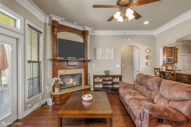 615 Canoe Trl, Bossier City, LA 71111 - living area with arched walkways, dark wood finished floors, ornamental molding, ceiling fan, and a brick fireplace