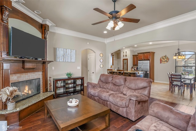 615 Canoe Trl, Bossier City, LA 71111 - living room featuring arched walkways, ceiling fan, ornamental molding, a glass covered fireplace, and a chandelier