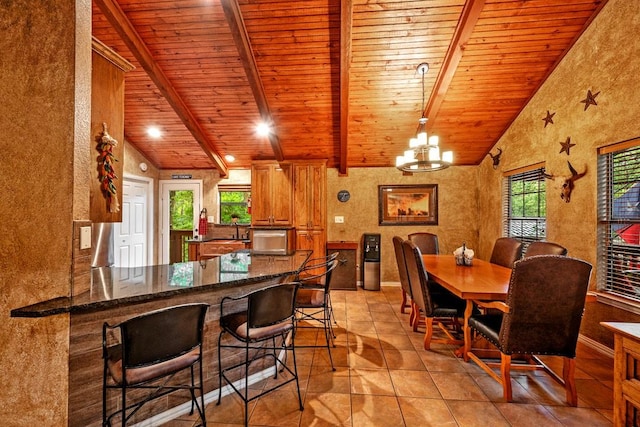 188 Hacienda, Pottsboro, TX 75076 - kitchen with wooden ceiling, brown cabinetry, a chandelier, a kitchen breakfast bar, and light tile patterned floors