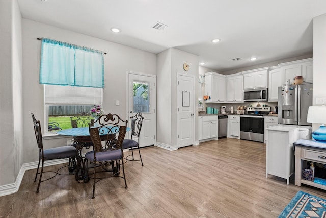 409 N Houston Ave, Denison, TX 75021 - kitchen with stainless steel appliances, light wood-style flooring, white cabinetry, and recessed lighting