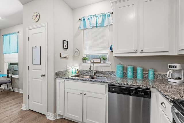 409 N Houston Ave, Denison, TX 75021 - kitchen with appliances with stainless steel finishes, light wood-style floors, dark stone countertops, and white cabinets